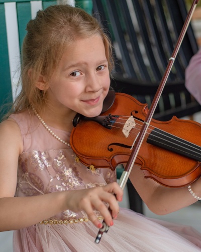 Caroline positioned to play while posing with a smile.