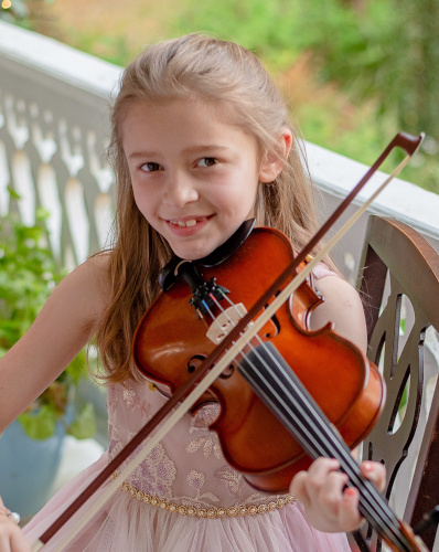 Madelynn Rose positioned to play while posing with a smile.