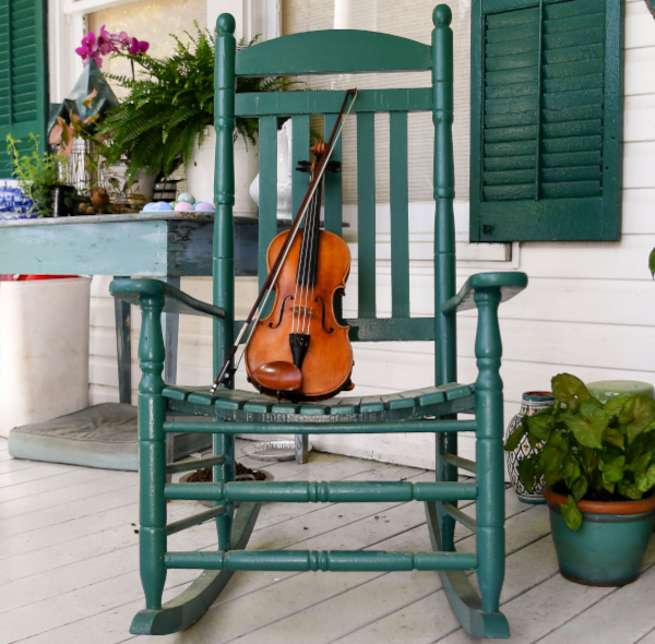 A violin from the 1800's sits on the porch rocker.